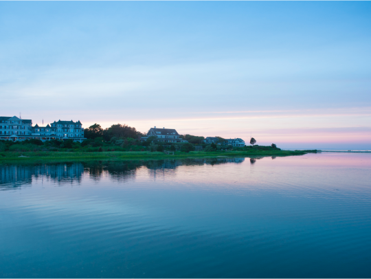View of the Harbor View Hotel from across the harbor during sunrise.