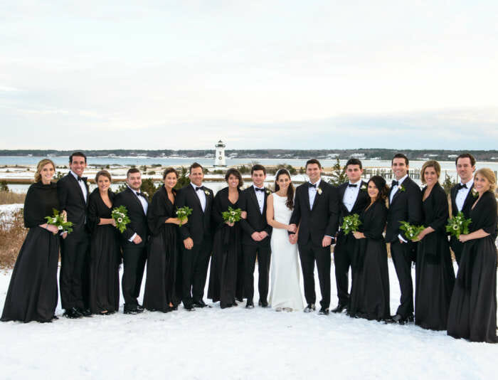 Bride and groom with wedding party taking photos outside in winter at Harbor View Hotel.