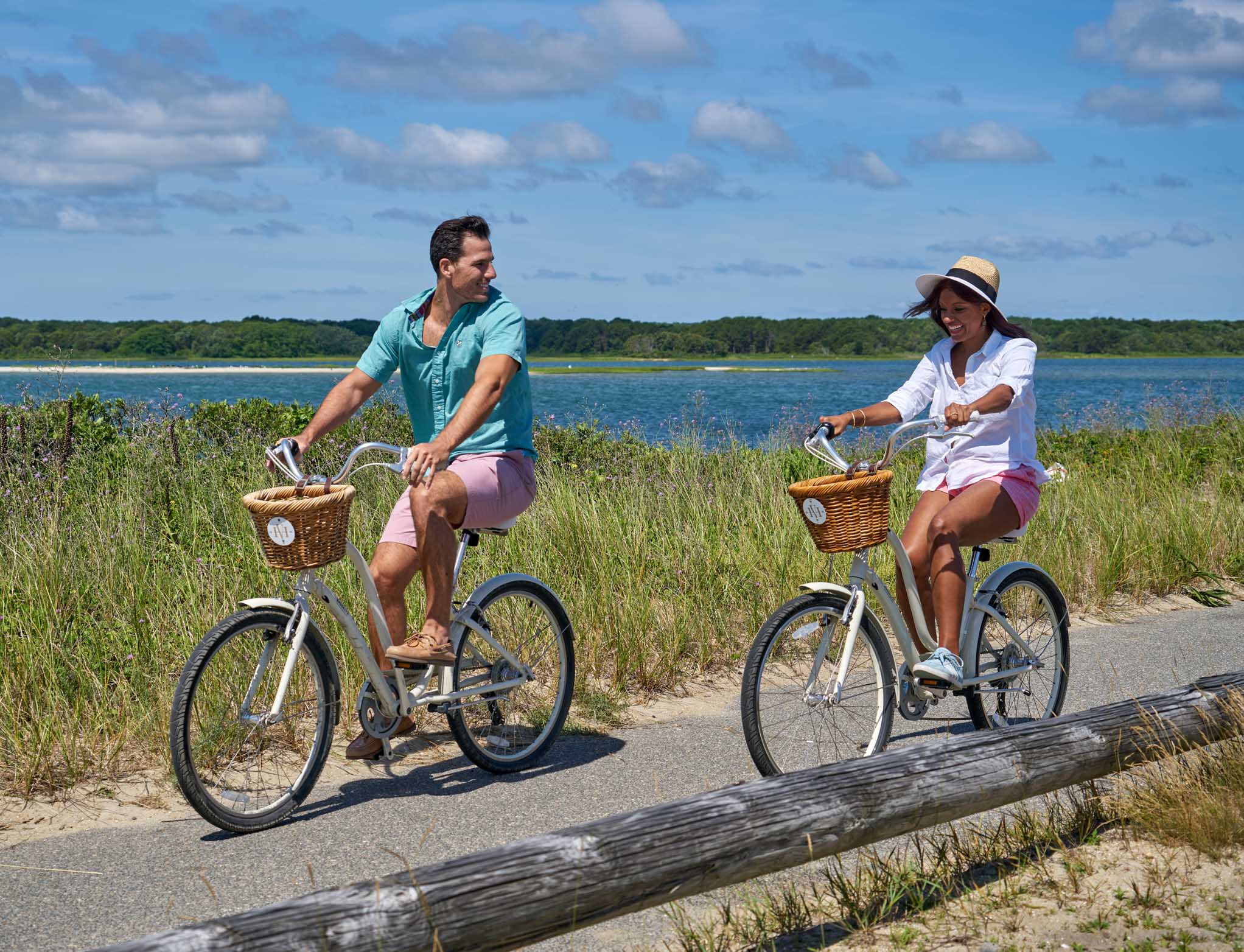 Couple riding bikes by the shore together