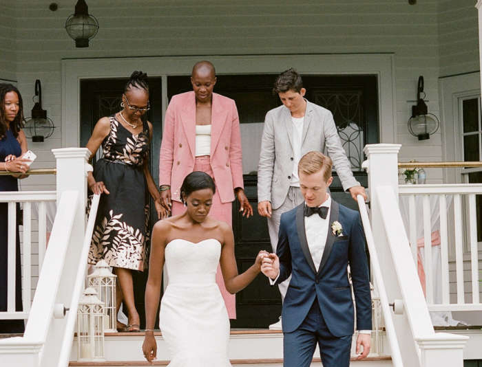 Bride and Groom walking down the stairs with family behind them at Harbor View Hotel.