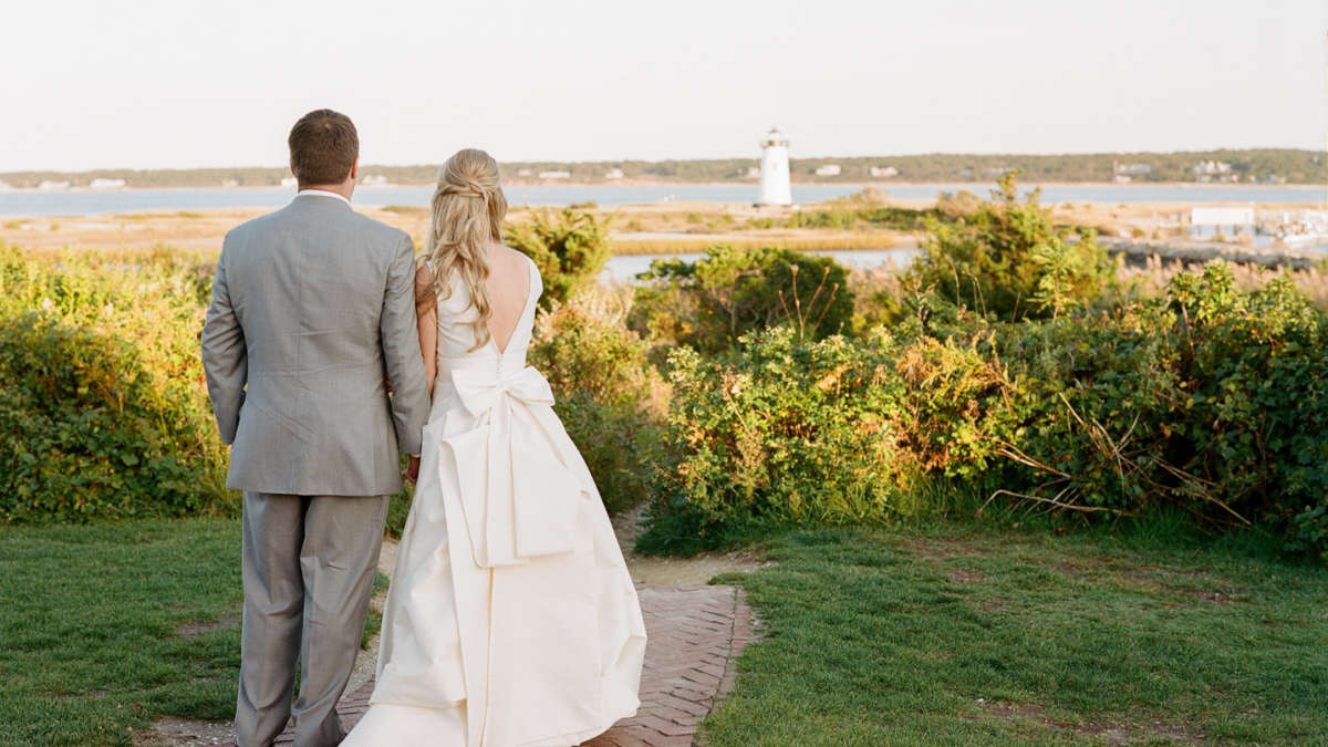 Bride and groom looking out at the Edgartown Lighthouse in front of Harbor View Hotel.
