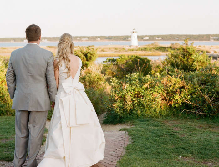 Bride and groom looking out at the Edgartown Lighthouse in front of Harbor View Hotel.