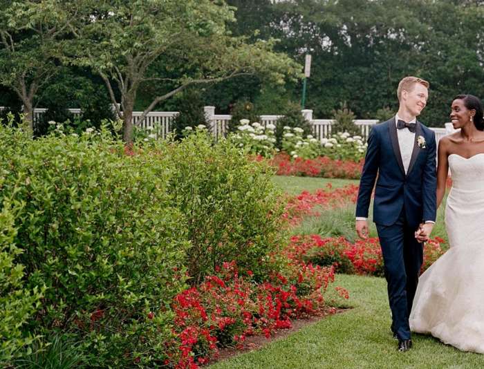 Bride and groom walking the Harbor View Hotel grounds together smiling.