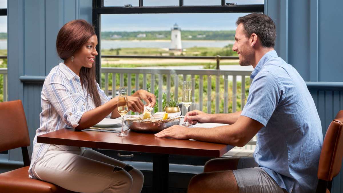 Couple eating dinner at a table with a view of the harbor