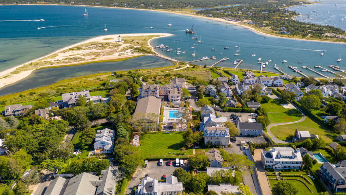 The harbor is from a drone. Perspective with views of homes, a pool, and a lighthouse.
