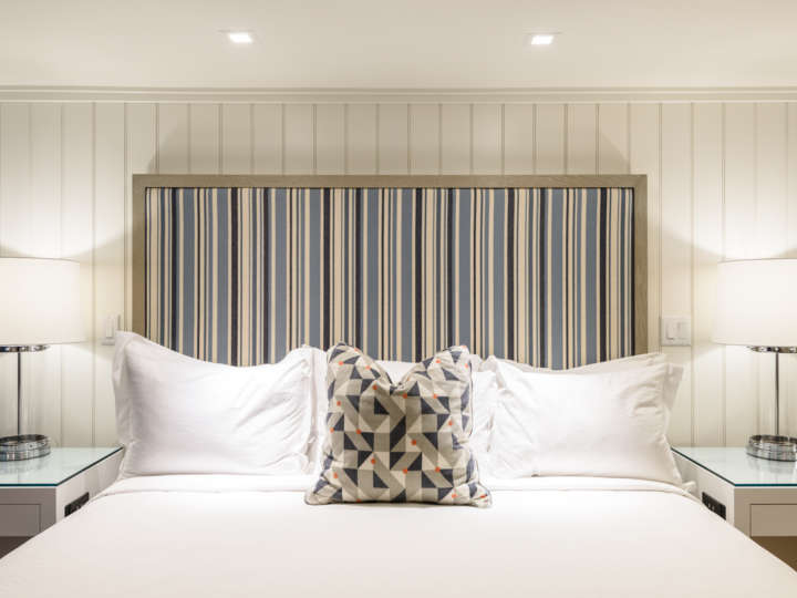 A king bed upholstered headboard in a Roxana guest room at the Harbor View Hotel.