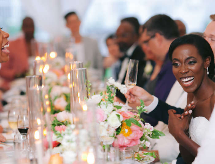Bride and groom laughing at dinner table with guests at Harbor View Hotel