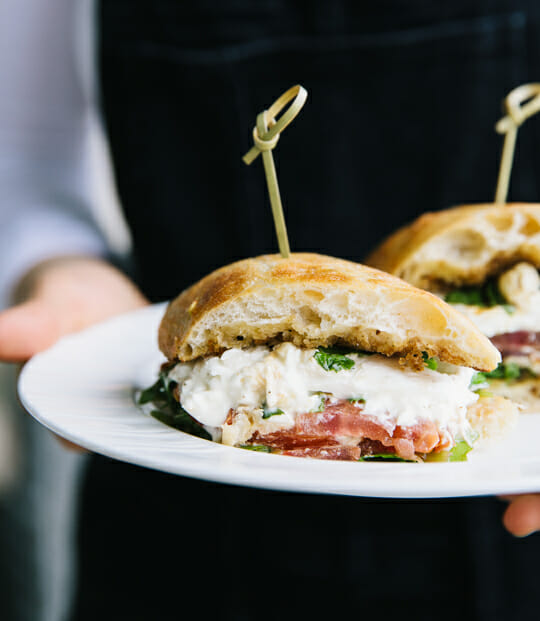 Plate with delicious looking sandwich being carried by a server