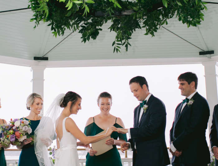 Bride and groom exchanging rings at under the gazebo at Harbor View Hotel.