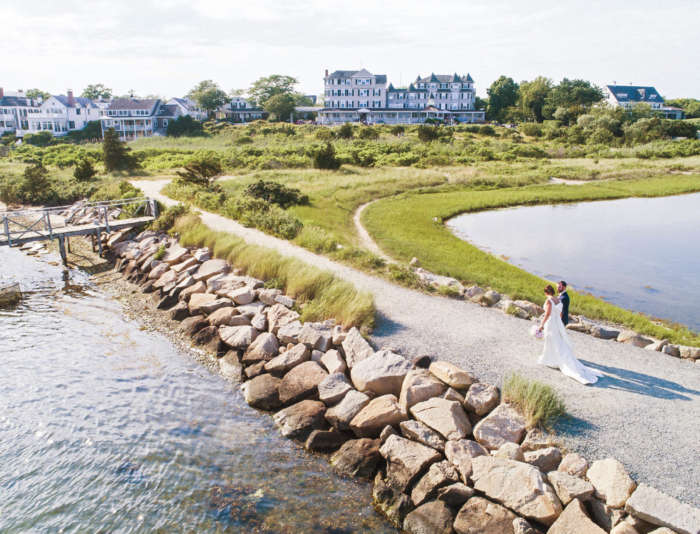 Bride and groom walking down Edgartown lighthouse beach path.