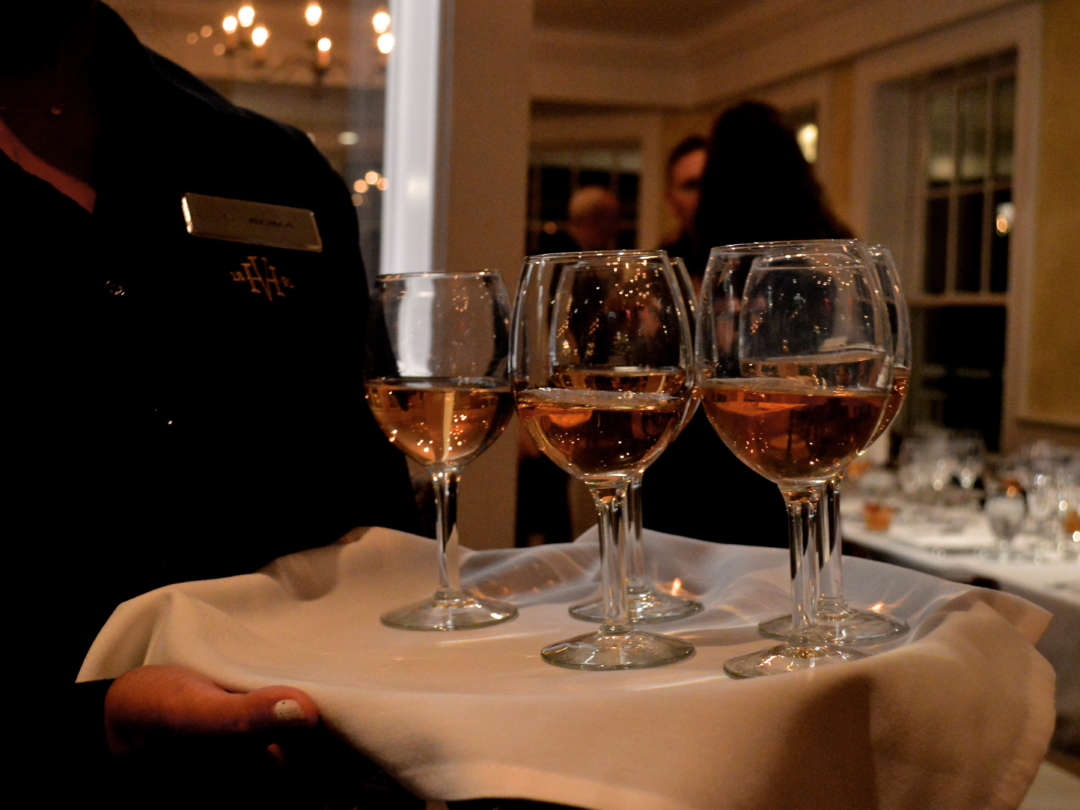 A server holding a tray of wines for a wine tasting in Bettini Restaurant.