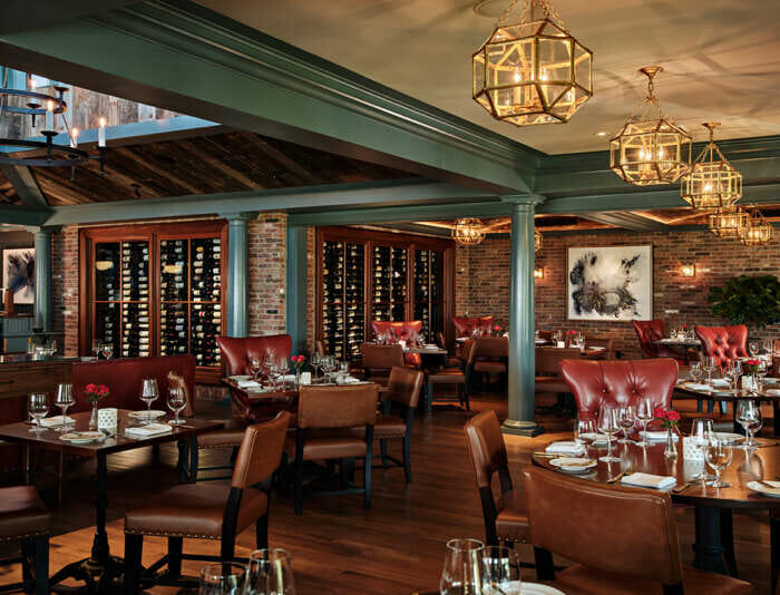 Bettini Restaurant set up for dinner service and a wine room in the background.