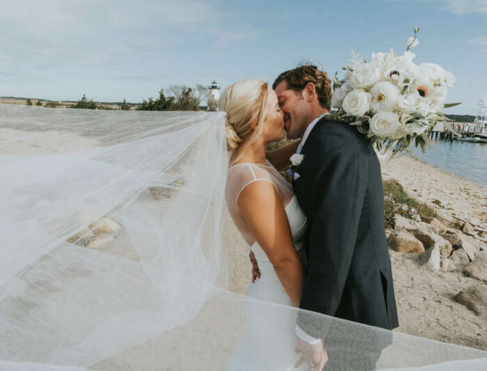A bride and groom kissing on the beach in Edgartown.