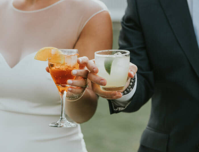 Two people holding craft cocktails at Harbor View Hotel.