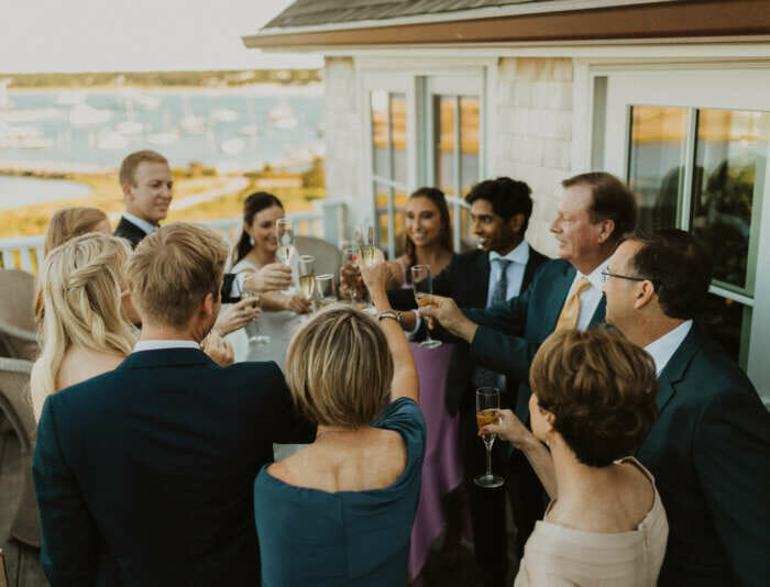A group of people cheering with champagne glasses at a wedding at Harbor View Hotel.