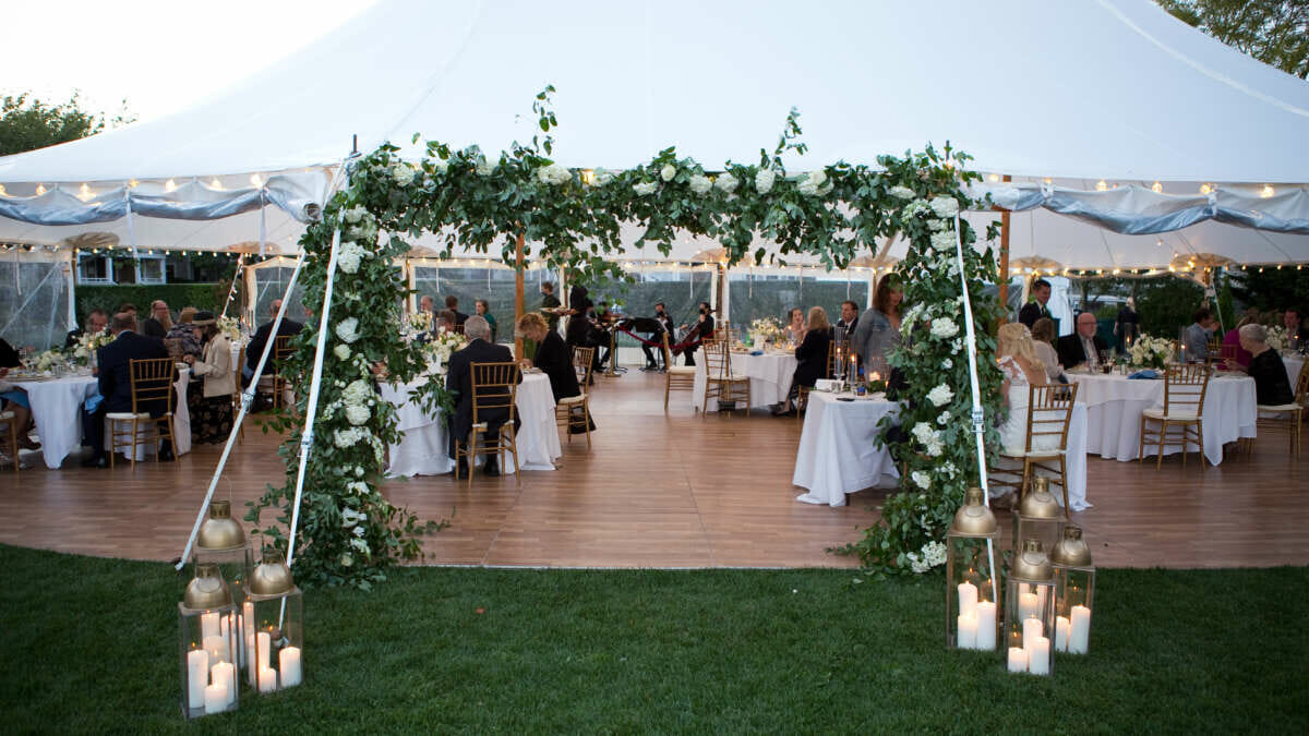 A wedding tent with decorated with flowers and lanterns at Harbor View Hotel.