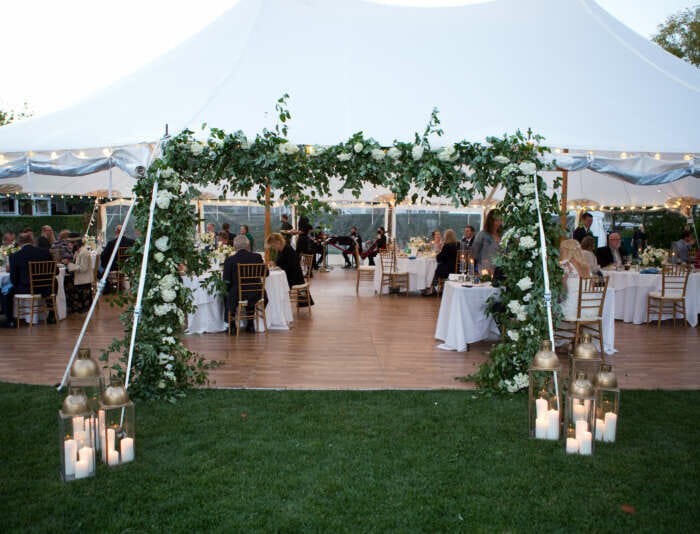 A wedding tent with decorated with flowers and lanterns at Harbor View Hotel.