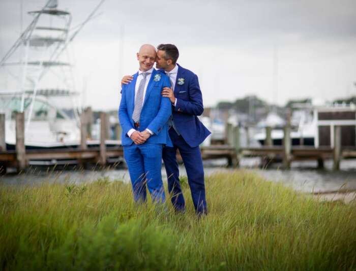 Two men holding each other next the the Edgartown Lighthouse.