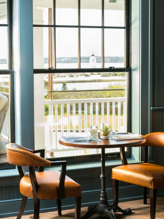 a table by a window with two chairs