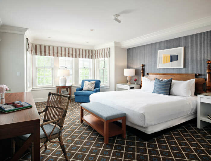 A Captain's Cottage master bedroom with a king bed at Harbor View Hotel.