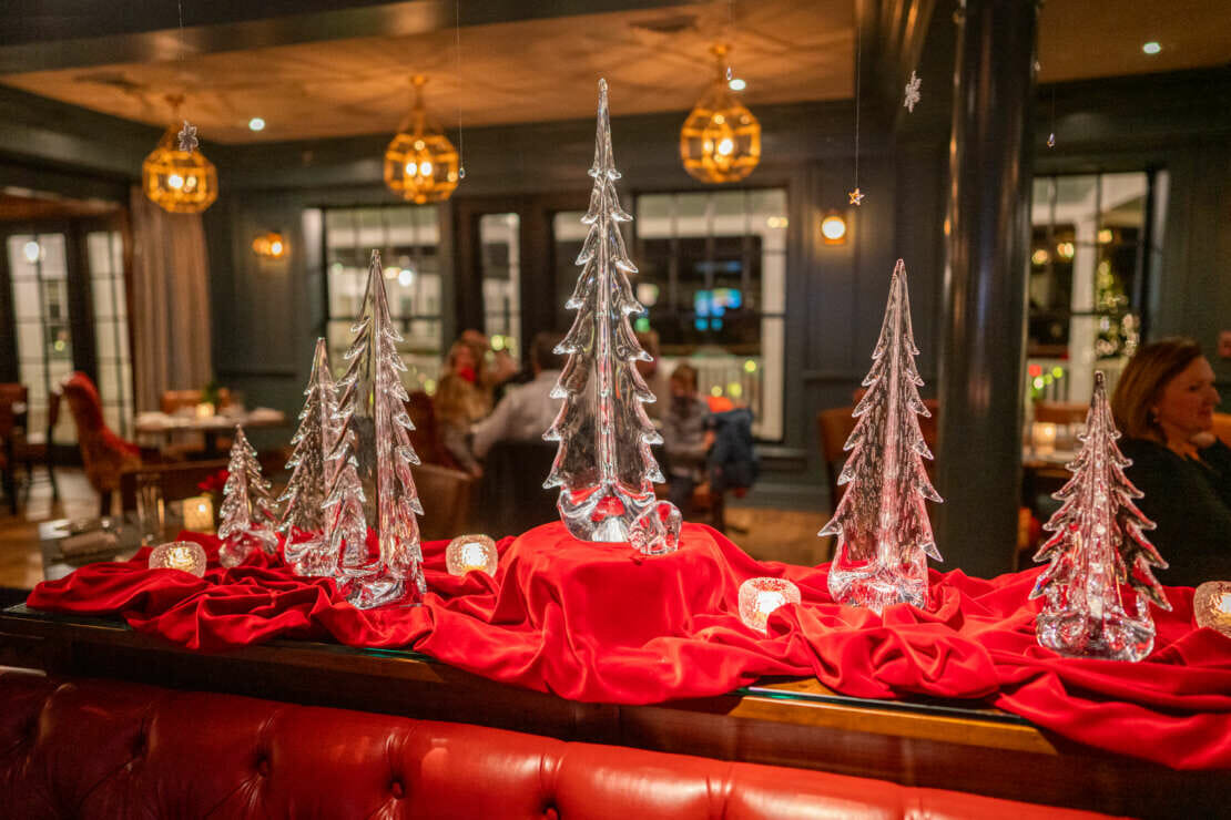 Simon Pearce glass-blown pine trees in Bettini Restaurant during the winter at Harbor View Hotel.