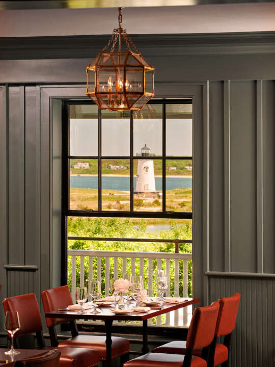 A table set for dinner at Bettini Restaurant at the Harbor View Hotel with a view of Edgartown Lighthouse.