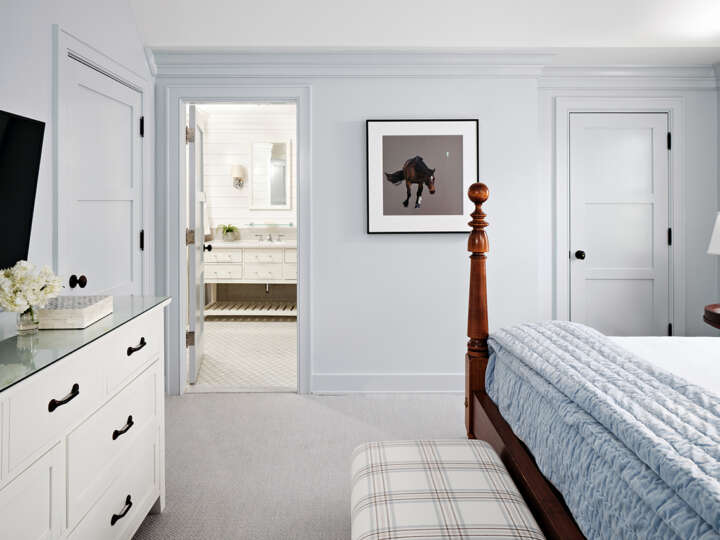 a corner of a bed and a white dresser with a room and a picture of a horse
