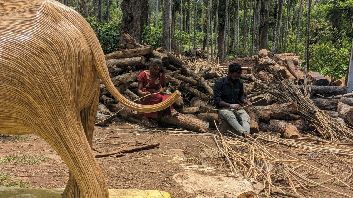 A man and a woman carving wood for the Elephant Sculpture.