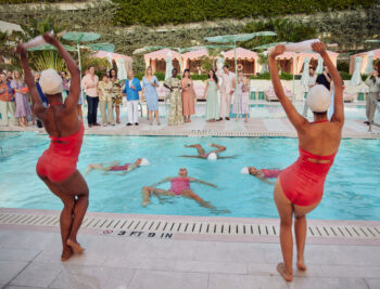 View of Aqualillies performers in the pool and dancing on the side of the pool in the daytime.