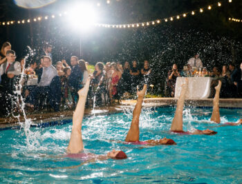 View of Aqualillies performers in the pool with a crowd watching.