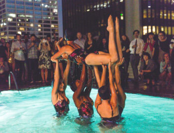 Aqualillies performers lifting a swimmer in the air.