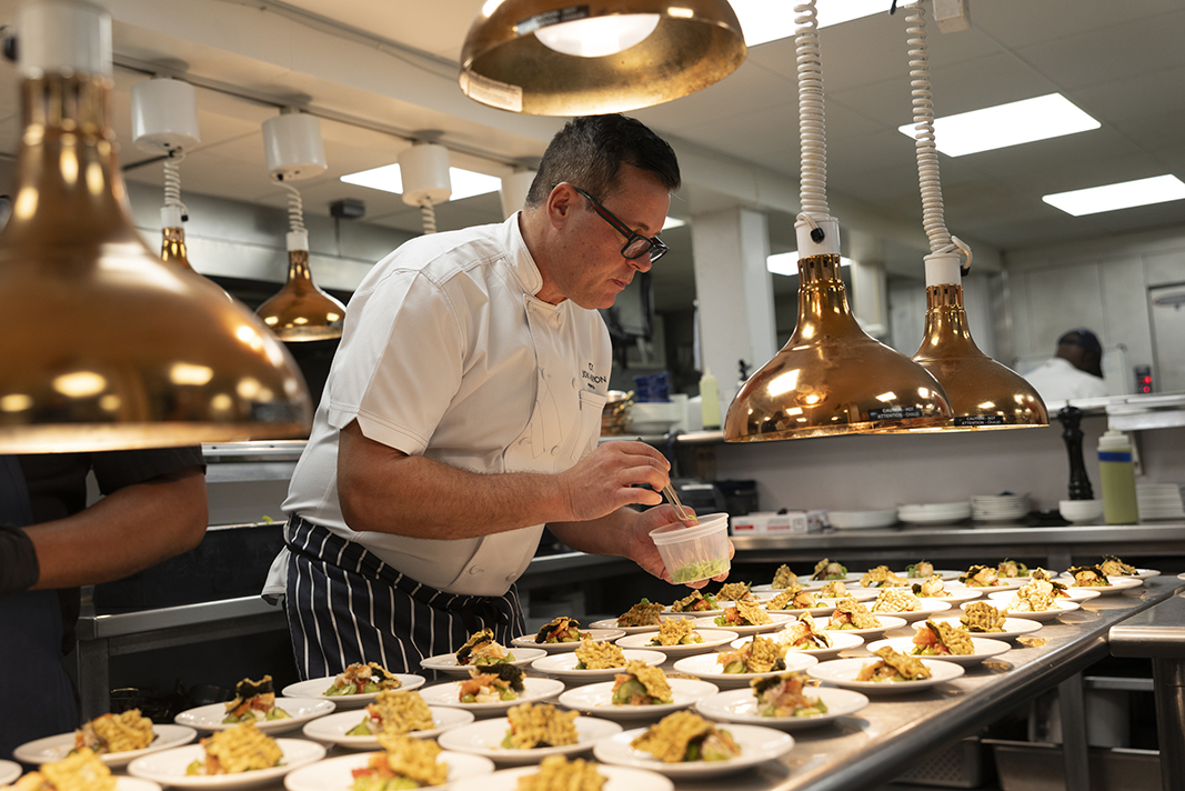 Chef Jon Ashton in the Bettini Kitchen preparing dishes.