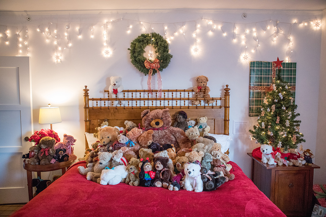 A collection of teddy bears on a bed at Harbor View Hotel.